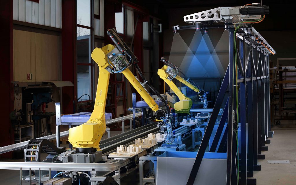 Bei Tür- und Torspezialist Hörmann entnehmen zwei Fanuc-Roboter mit Vision-System auf einer Linearachse die Produktkomponenten aus Großladungsträgern.