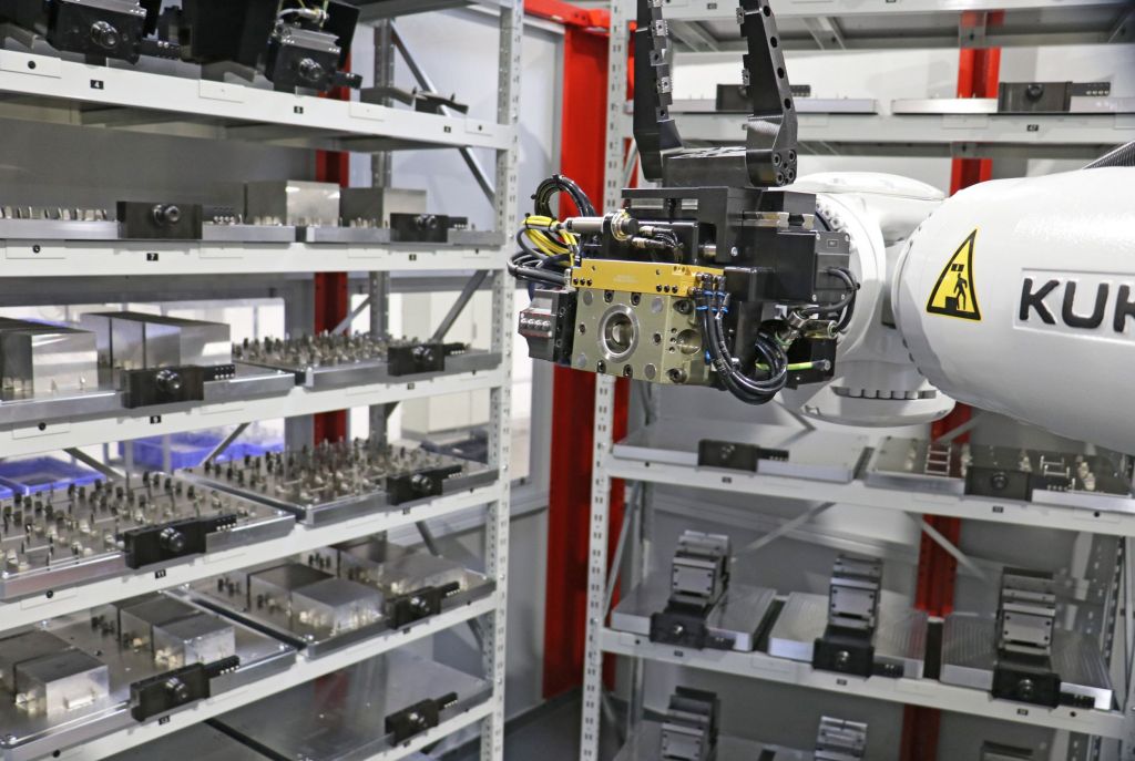 Ein Roboter versorgt das 5-Achs-Bearbeitungszentrum mit vorgerüsteten Werkstückpaletten.